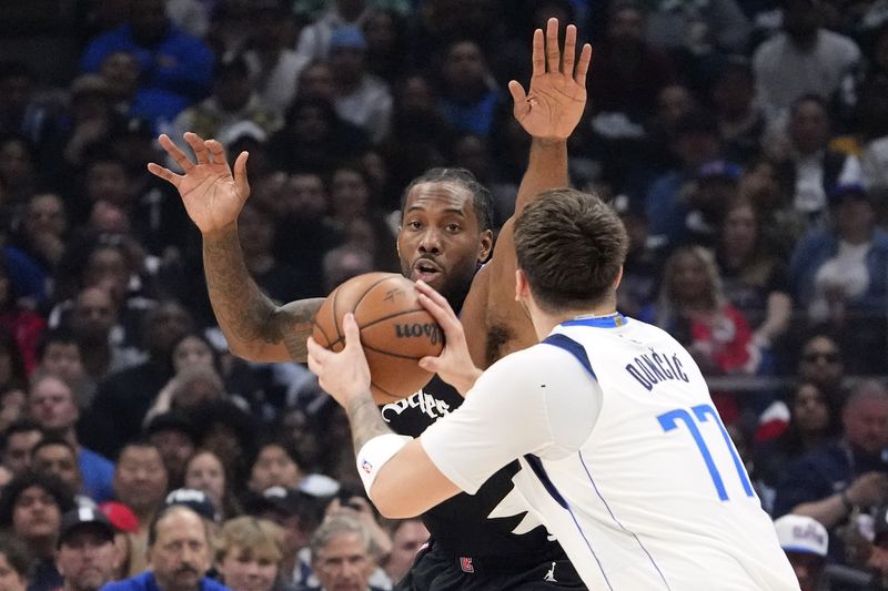 Dallas Mavericks guard Luka Doncic, right, tires to shoot as Los Angeles Clippers forward Kawhi Leonard defends during the first half in Game 2 of an NBA basketball first-round playoff series Tuesday, April 23, 2024, in Los Angeles. (AP Photo/Mark J. Terrill)