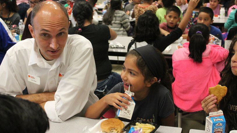 Atlanta Community Food Bank Vice President of Programs Jon West talks with children at a Hall County school during one of the organization’s events promoting summer meals. CONTRIBUTED