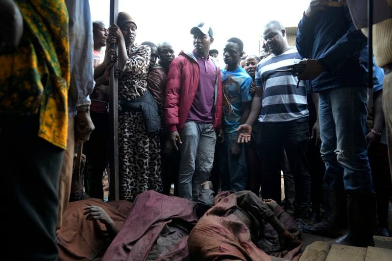 Residents gather around the covered dead body of a women retrieved from a house, after heavy rain in the Mathare slum of Nairobi, Kenya, Wednesday, Apr. 24, 2024. Heavy rains pounding different parts of Kenya have led to the deaths of at least 35 people since mid-March and displaced more than 40,000 people, according to the U.N., which cites Red Cross figures in the most recent update. (AP Photo/Brian Inganga)