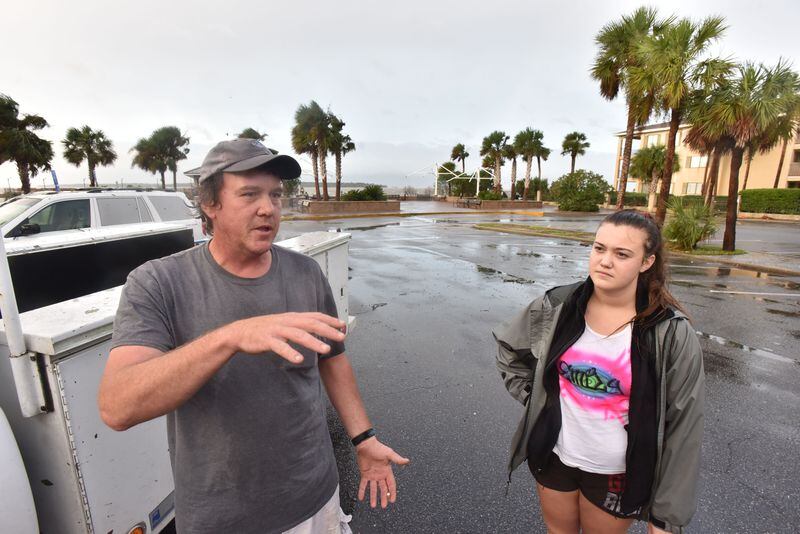 Timothy Seavey, of St. Simons Island, talks as his daughter Emily looks near St. Simons Island Pier on Saturday morning, Oct. 8, 2016. Hurricane Matthew knocked out power, sent trees crashing down on houses and over roads and flooded parking lots and yards across St. Simons Island. Frederica Road near the air strip is covered with fallen trees. HYOSUB SHIN / HSHIN@AJC.COM