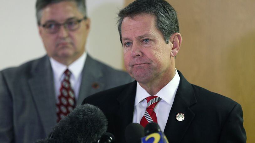 Georgia Secretary of State Brian Kemp (right) and Russell Lewis, chief investigator with the Secretary of State’s Office, spoke at a press conference early Monday at Peachtree DeKalb Airport to talk about the state’s election readiness, before flying around the state to deliver the same message. BOB ANDRES /BANDRES@AJC.COM