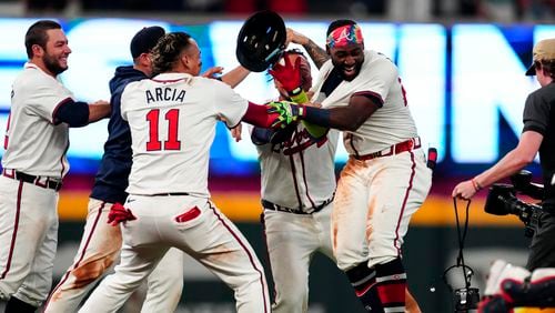 Atlanta Braves' Michael Harris II, right, is mobbed by teammates after driving in the game-winning run with a single in the 10th inning of a baseball game against the Miami Marlins Wednesday, April 24, 2024, in Atlanta. (AP Photo/John Bazemore)