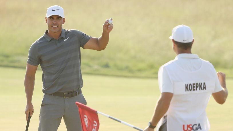 Brooks Koepka begins a muted celebration after putting out on 18 Sunday, with a second U.S. Open title near. (Streeter Lecka/Getty Images)