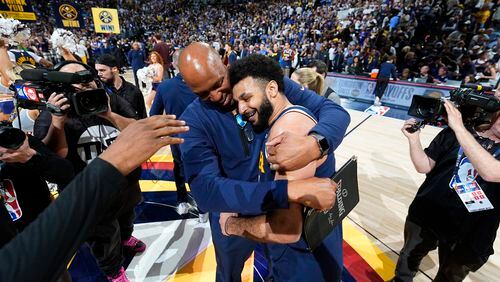 Denver Nuggets assistant coach Popeye Jones, left, hugs guard Jamal Murray after Game 5 of an NBA basketball first-round playoff series against the Los Angeles Lakers Monday, April 29, 2024, in Denver. Murray scored 32 points despite a strained calf and sank the game-winner with 3.6 seconds left to win over the Lakers. (AP Photo/David Zalubowski)
