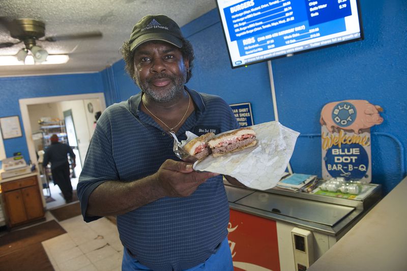 Owner J. Byron Long showcases one of Blue Dot's greasy burgers and barbecue sauce.  Courtesy of Visit Pensacola