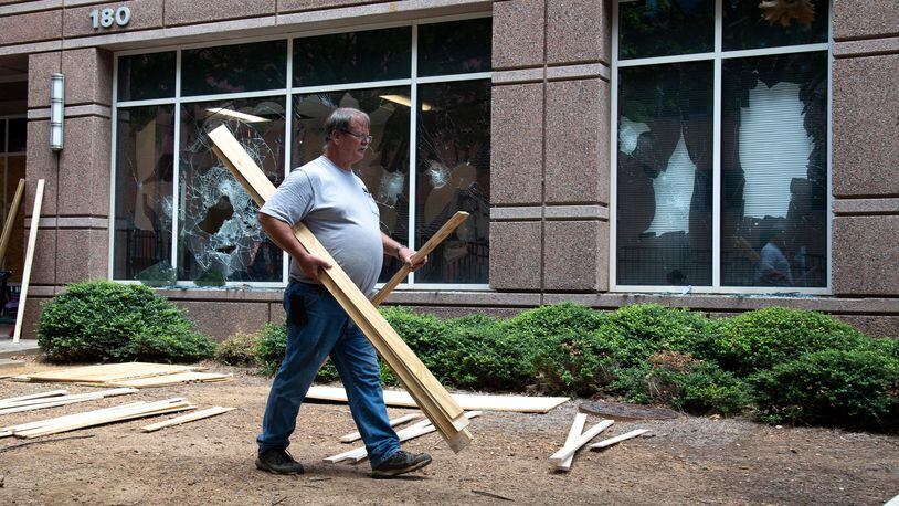 Workers make repairs to the Department of Homeland Security and Immigration and Customs Enforcement field offices in Atlanta on July 26, 2020, a day after the building was vandalized by protesters.