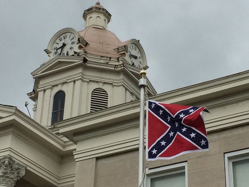 The Confederate battle flag flies outside the Chattooga County Courthouse in Summerville, Ga. The flag, which was flying on the 150th anniversary of the surrender of the Confederate forces at Appomatox, was put up with county approval by the local Sons of Confederate Veterans chapter. (Rosalind Bentley / AJC file)