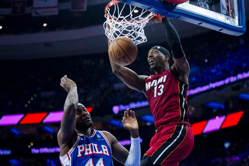 Miami Heat's Bam Adebayo, right, dunks over Philadelphia 76ers' Paul Reed during the first half of an NBA basketball play-in tournament game Wednesday, April 17, 2024, in Philadelphia. (AP Photo/Chris Szagola)