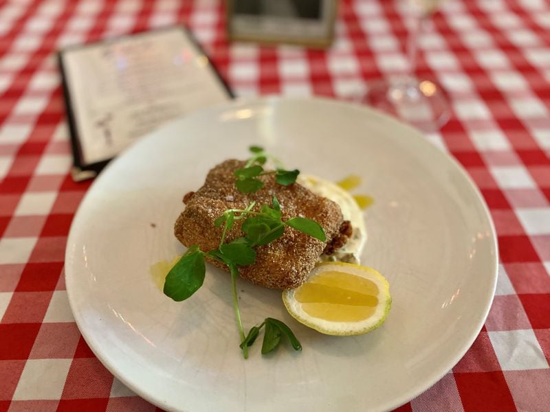 Gigi’s fish Milanese is a perfectly fried hunk of mahi mahi with aioli, capers and lemon. Wendell Brock for The Atlanta Journal-Constitution
