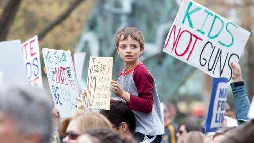 A boy holds up a sign during the March for Our Lives in Atlanta on Saturday, March 24, 2018.  The event, in response to the Parkland school shooting that killed 17 people, drew 60,000 marchers to downtown Atlanta.