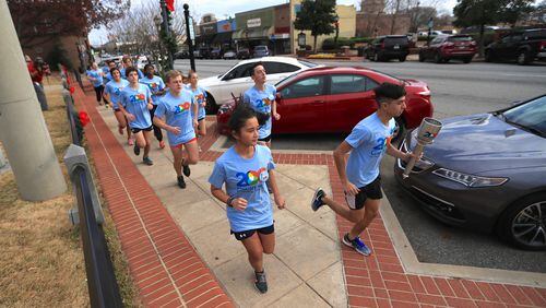 Students representing Gwinnett high schools carries the county’s bicentennial torch to help kick off a year of celebration. Courtesy Gwinnett County