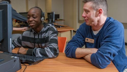 Mike Riley (right), a technology teacher at Lanier High in Sugar Hill, piloted the EarSketch program that teaches students to compose original music through coding. Contributed.