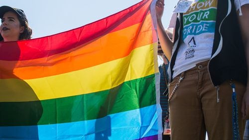 A Kennesaw State student holds an LGBT flag during a protest at the school. (AJC/Cory Hancock)