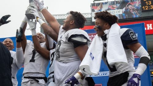 Eagle's Landing Christian Academy players hold up the trophy after beating Wesleyan High School during the Class A private state title football championship game at Georgia State Stadium Friday, December 13, 2019. STEVE SCHAEFER / SPECIAL TO THE AJC