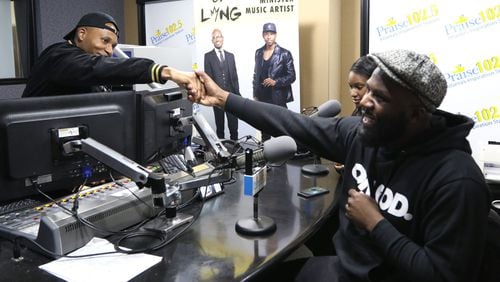 Edward Long (left), a host, shakes hands with Iamfreewil, a local artist, during his radio show on Praise 102.5. Long says that he loves to say things that some people might consider out there to get a dialogue started. EMILY HANEY / EMILY.HANEY@AJC.COM