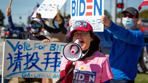 
Asian Americans Democratic Club chairwoman Bilan Liao  leads a groop in chants during a Chinese for Biden sign-waving rally along Pleasant Hill Rd  Saturday, October 17, 2020.   STEVE SCHAEFER / SPECIAL TO THE AJC 