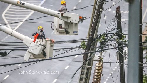 Workers continue to try to restore power along Hammond Drive in Sandy Springs on the morning of Tuesday, Sept. 12, 2017. More than 1.2 million Georgians remained without power the morning after Tropical Storm Irma passed through the state. (John Spink / jspink@ajc.com)