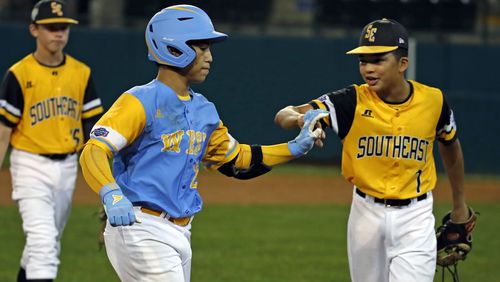 Hawaii's Aukai Kea (left) is greeted by Peachtree City's Tai Peete (7) as he rounds third after hitting a walk off, two-run home run in the eleventh inning of the Little League World Series tournament  Friday, Aug. 17, 2018, in South Williamsport, Pa.