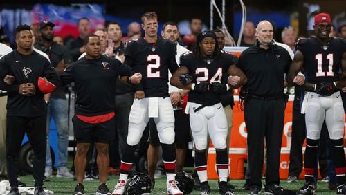 Atlanta Falcons stand arm-and-arm during the national anthem before the first half of an NFL football game between the Atlanta Falcons and the Buffalo Bills, Sunday, Oct. 1, 2017, in Atlanta. (AP Photo/John Bazemore)