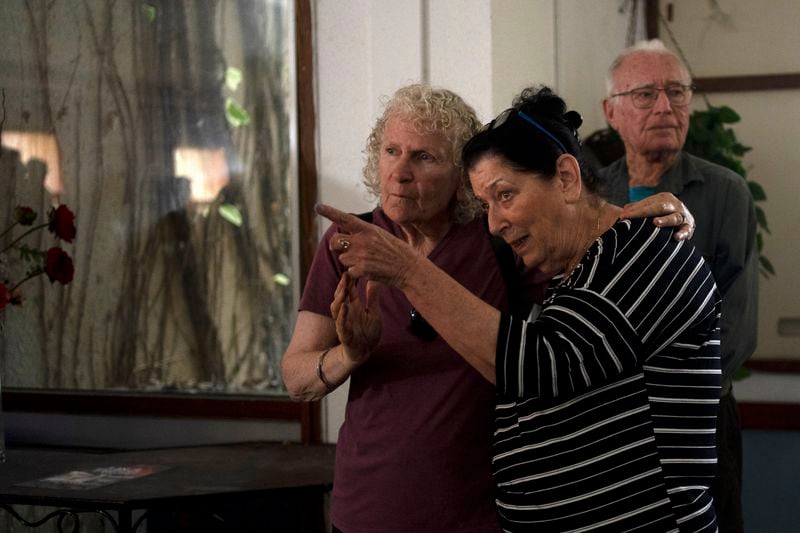 Osnat Peri, right, whose husband, Hair is in Hamas captivity, takes part in a Passover Seder commemoration with relatives of hostages held in the Gaza Strip, at the communal dining room at Kibbutz Nir Oz, Thursday, April 11, 2024. For many Jews, no matter how observant, Passover is a time to unite with family to eat and drink around what's known as a Seder table, remembering how the Jews persevered through harsh times. But this year, when Passover begins on Monday, many families are torn on how to celebrate, or if it's worth acknowledging at all. (AP Photo/Maya Alleruzzo)
