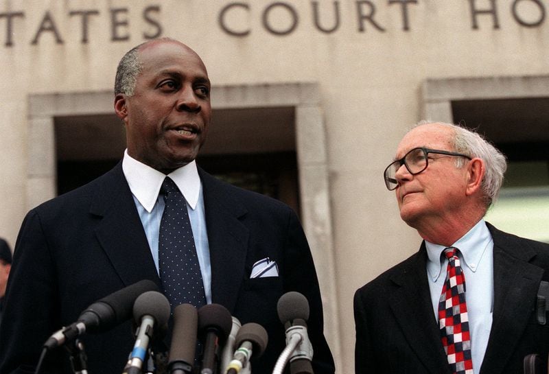 Vernon Jordan, accompanied by attorney William Hundley, meets with reporters outside federal court in Washington in 1998. Jordan died March 1 at the age of 85. (AP Photo/Khue Bui)