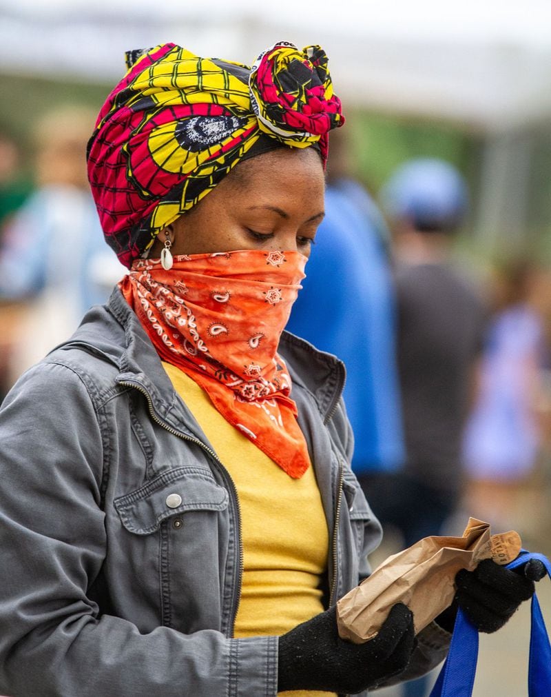 Ko Forte looks over her purchase Saturday at the Carter Center Farmers Market, March 28, 2020. STEVE SCHAEFER / SPECIAL TO THE AJC