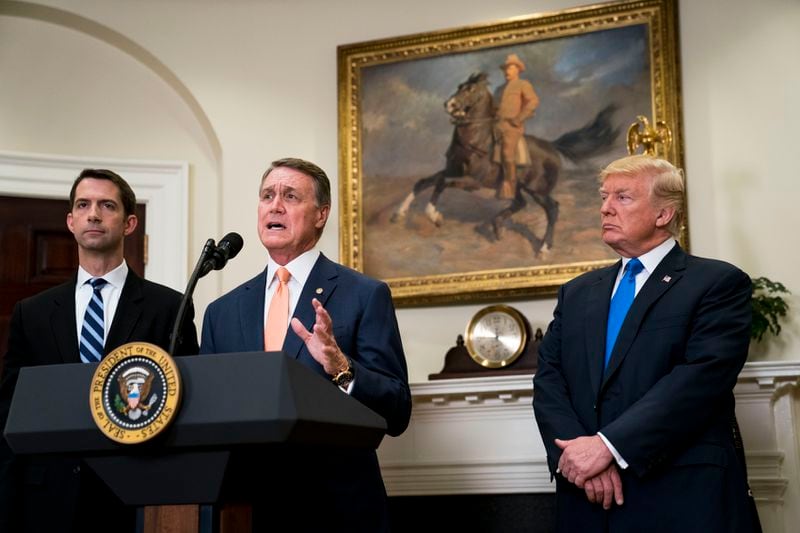 Sen. David Perdue (R-Ga.) discusses the Raise Act, immigration legislation he and Sen. Tom Cotton (R-Ark.), left, are sponsoring, with President Donald Trump at the White House in Washington, Aug. 2, 2017. The bill would overhaul decades of immigration policy by replacing a system that favors family ties in deciding who can move to the United States legally with merit-based preferences based on skills and employability. (Doug Mills/The New York Times)