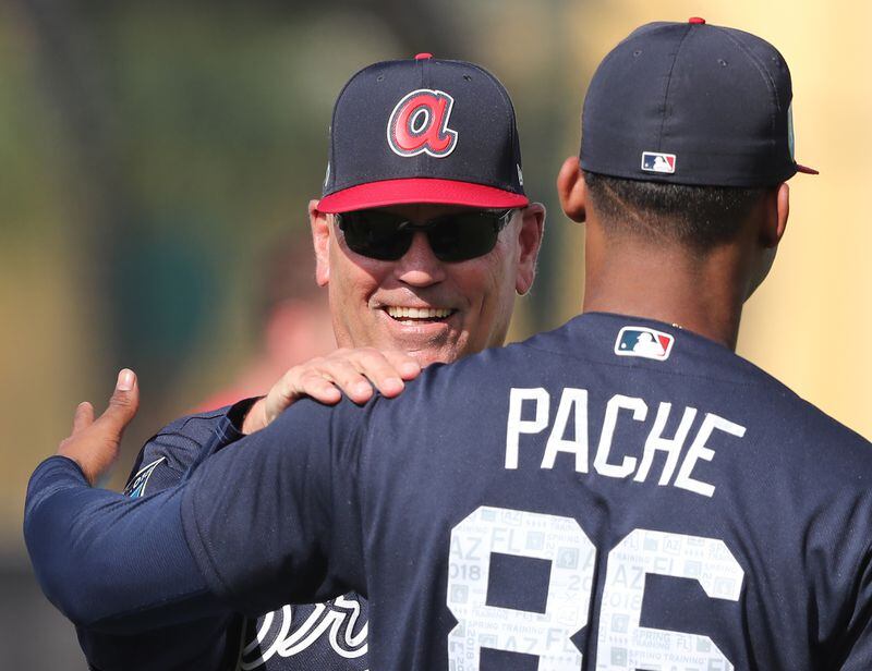 Braves manager Brian Snitker shares a laugh with outfielder Cristian Pache early in spring training.  (Curtis Compton/ccompton@ajc.com)