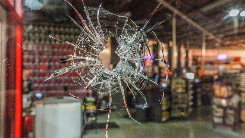 An AutoZone store was one of several businesses damaged by bullets when a gunman opened fire at two truck drivers and a police officer in a DeKalb County shopping center. JOHN SPINK / JSPINK@AJC.COM