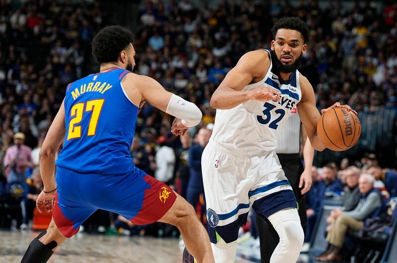 Minnesota Timberwolves center Karl-Anthony Towns, right, drives past Denver Nuggets guard Jamal Murray, left, in the second half of Game 1 of an NBA basketball second-round playoff series Saturday, May 4, 2024, in Denver. (AP Photo/David Zalubowski)