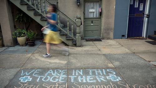 A Savannah resident in April walks past a sidewalk caulk message with an encouraging tone amid the pandemic. (Stephen B. Morton for The Atlanta Journal-Constitution)