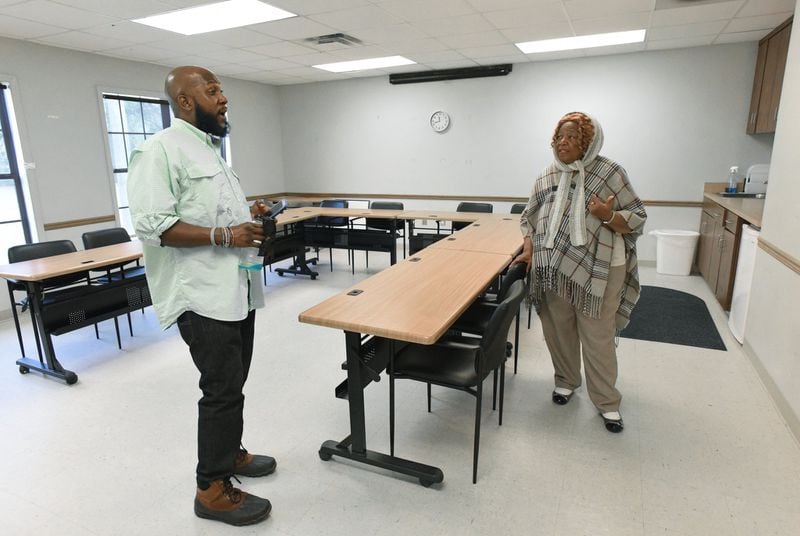 Pastor Shirley Cody (right), who helped organize transportation for her church’s voters on Election Day last year, talks with her godson Travis K. McCray in the room where voting was taking place last year, in Fort Gaines on Tuesday, Dec. 10, 2019. HYOSUB SHIN / HYOSUB.SHIN@AJC.COM