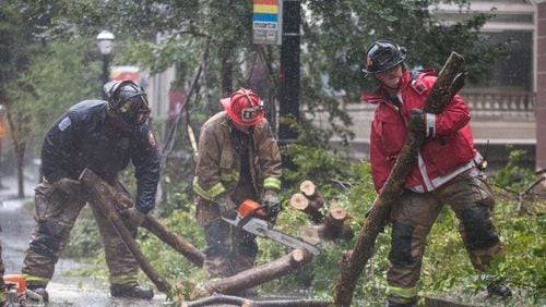 Atlanta firefighters work to clear a downed tree on 14th Street near Peachtree Street in downtown Atlanta, Monday, Sept. 11, 2017.  BRANDEN CAMP/SPECIAL
