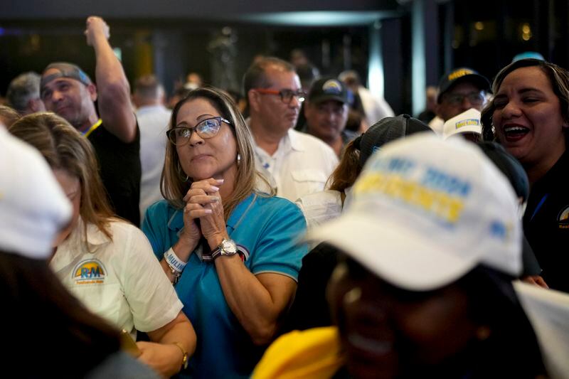 Supporters of Achieving Goals presidential candidate Jose Raul Mulino react to early results after the closing of polls for general elections in Panama City, Sunday, May 5, 2024. (AP Photo/Matias Delacroix)