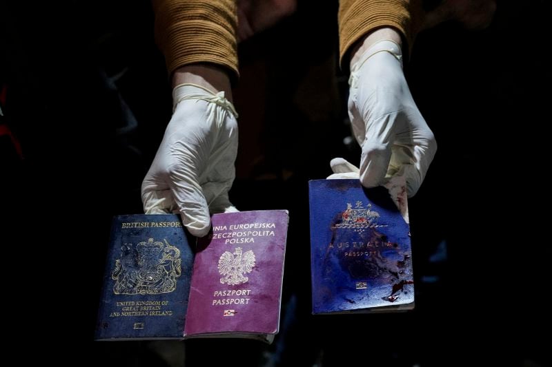 A man displays blood-stained British, Polish, and Australian passports after an Israeli airstrike, in Deir al-Balah, Gaza Strip, Monday, April 1, 2024. Gaza medical officials say an apparent Israeli airstrike killed four international aid workers with the World Central Kitchen charity and their Palestinian driver after they helped deliver food and other supplies to northern Gaza that had arrived hours early by ship. (AP Photo/Abdel Kareem Hana)