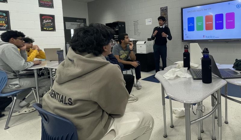 Raj Mehta, a senior at Forsyth County's Lambert High School, is leading a workshop at Denmark High School. Here, he is explaining how credit affects a person's life. Courtesy of Raj Mehta