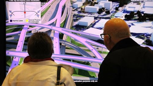 Halina and Constantine Gaurilidis of Sandy Springs watch a visualization of the proposed I-285 Top End Express Lanes during a public meeting Tuesday. The Georgia Department of Transportation is seeking public comment on its latest plans for the toll lanes. Curtis Compton ccompton@ajc.com