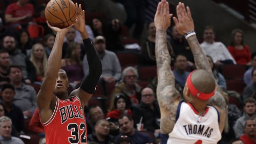 Chicago Bulls guard Kris Dunn, left, shoots against Washington Wizards guard Isaiah Thomas during the second half of an NBA basketball game in Chicago, Wednesday, Jan. 15, 2020. The Bulls won 115-106. (AP Photo/Nam Y. Huh)