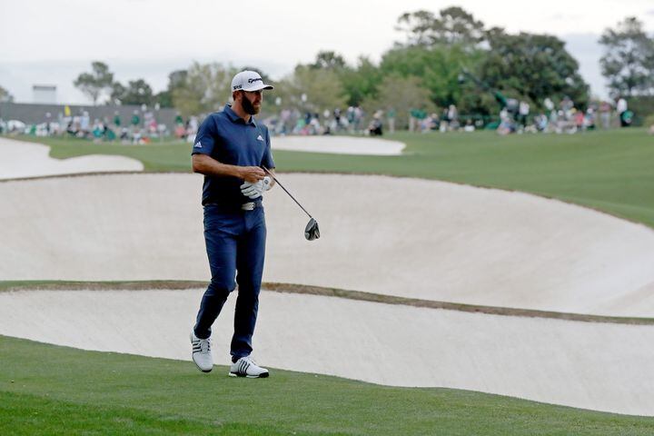 April 9, 2021, Augusta: Dustin Johnson looks over his shot in the fairway bunker on the eighteenth hole during the second round of the Masters at Augusta National Golf Club on Friday, April 9, 2021, in Augusta. Curtis Compton/ccompton@ajc.com