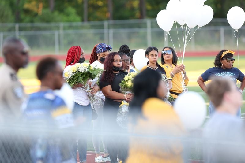 The Eagle's Landing High School football stadium was crowded with white balloons Monday evening during a vigil to remember the four students who were killed.