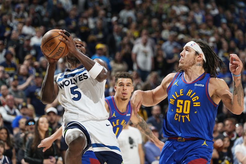 Minnesota Timberwolves guard Anthony Edwards, left, drives to the basket as Denver Nuggets forward Aaron Gordon defends in the second half of Game 1 of an NBA basketball second-round playoff series Saturday, May 4, 2024, in Denver. (AP Photo/David Zalubowski)