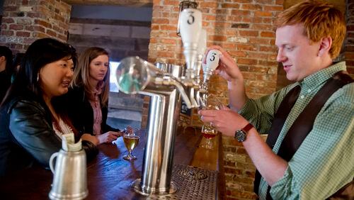 Danny Ritchie (right) pours a beer for Hannah Cho (left) and Natalie Rogol at Three Taverns Craft Brewery in Decatur in this file photo.