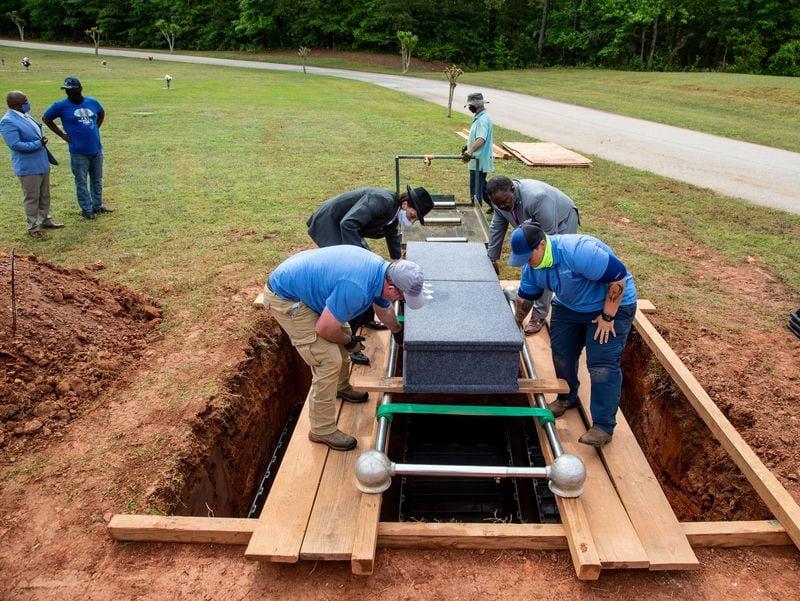 The second coffin of the three is moved to the burial site after a short service at Lakeside Memorial Garden. (Steve Schaefer for The Atlanta Journal-Constitution)