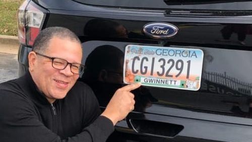 Former Fulton County Commission Chairman John Eaves points to his license plate to show he now lives in Gwinnett County, where he’s running in the 7th Congressional District. Some U.S. House candidates in metro Atlanta are drawing criticism from rivals because they don’t live within the districts they hope to represent in Congress.