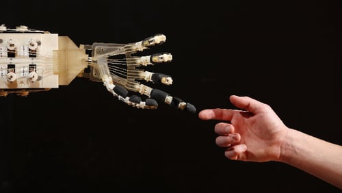Robotics student Gildo Andreoni interacts with a Dexmart robotic hand built at the University of Bologna in the Robotville exhibition at the Science Museum on November 29, 2011 in London, England.