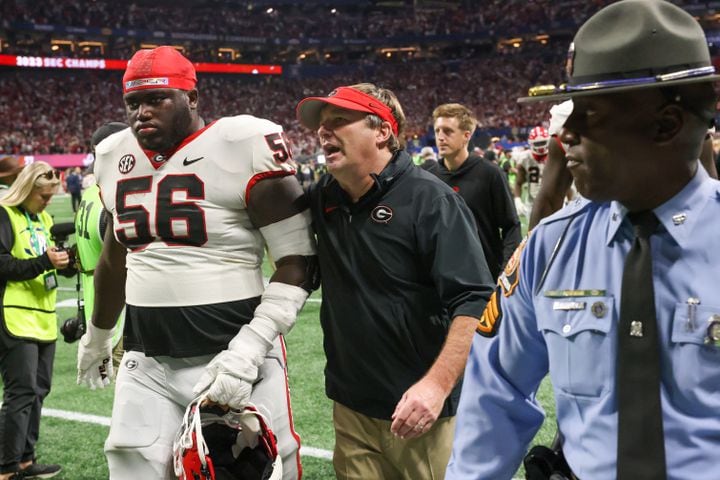 Georgia Bulldogs head coach Kirby Smart and offensive lineman Micah Morris (56) walk off the field following the SEC Championship football game at the Mercedes-Benz Stadium in Atlanta, on Saturday, December 2, 2023. Alabama defeated Georgia 27-24 to end the Bulldogs’ 29-game winning streak. (Jason Getz / Jason.Getz@ajc.com)