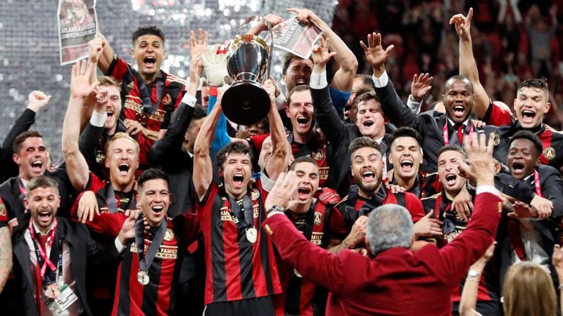 Members of The Atlanta United soccer team hoists the MLS Cup Saturday night after winning the championship game of the Major League Soccer League at Mercedes-Benz Stadium in Atlanta. On Monday, the team hoisted the cup at Magic City. BOB ANDRES / BANDRES@AJC.COM