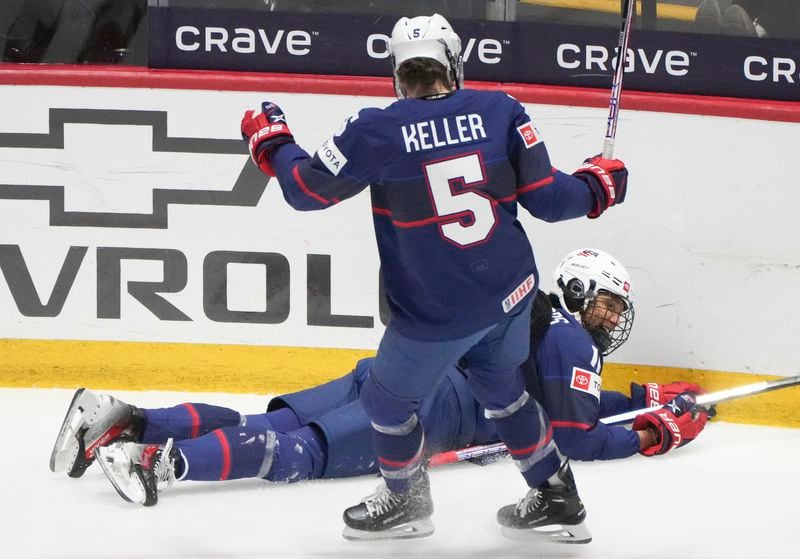 United States' Laila Edwards (14) celebrates her goal on Canada with teammate Megan Keller (5) during the first period in the final at the IIHF Women's World Hockey Championships in Utica, N.Y., Sunday, April 14, 2024. (Christinne Muschi/The Canadian Press via AP)
