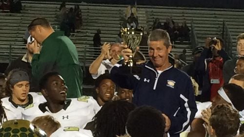Jeff Herron shows off the Region 8-AAAAAAA championship trophy his team won in his first and only season at Grayson, which would go on to win the state title.