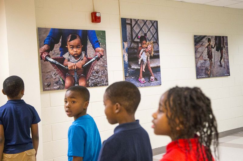 Images created by award winning American photographer Steve McCurry are displayed on the walls as students navigate the hallways at Harper Archer Elementary School, Wednesday, February 26, 2020. (ALYSSA POINTER/ALYSSA.POINTER@AJC.COM)